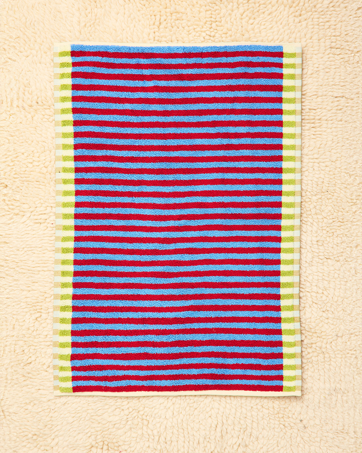 Striped rug with red, blue, and green stripes on a beige background