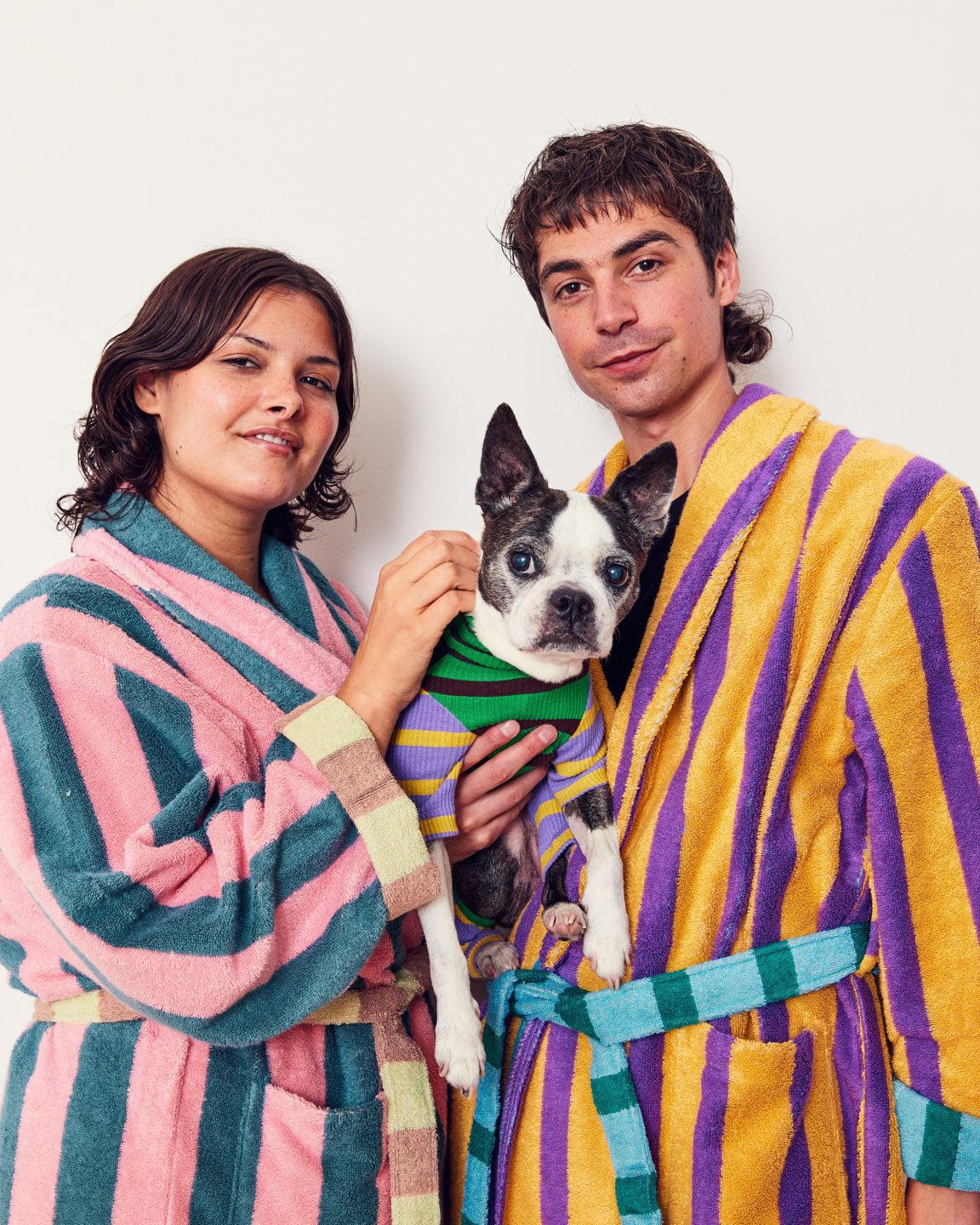 Person in Ronnie Stripe Bathrobe with woman in pink Martine robe with dog in middle