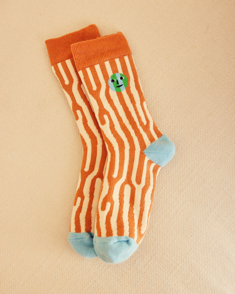 oak pattern socks in orange and cream with blue heel and toe on beige background