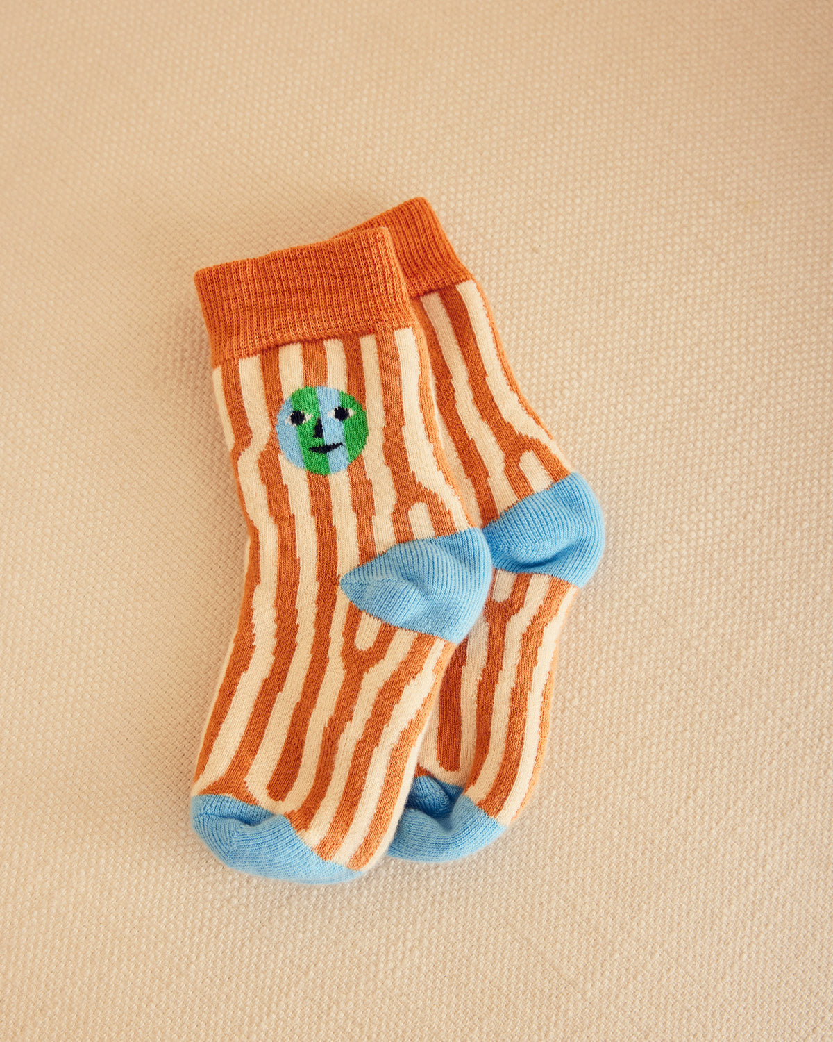 oak pattern socks in brown and cream with blue heel on beige couch