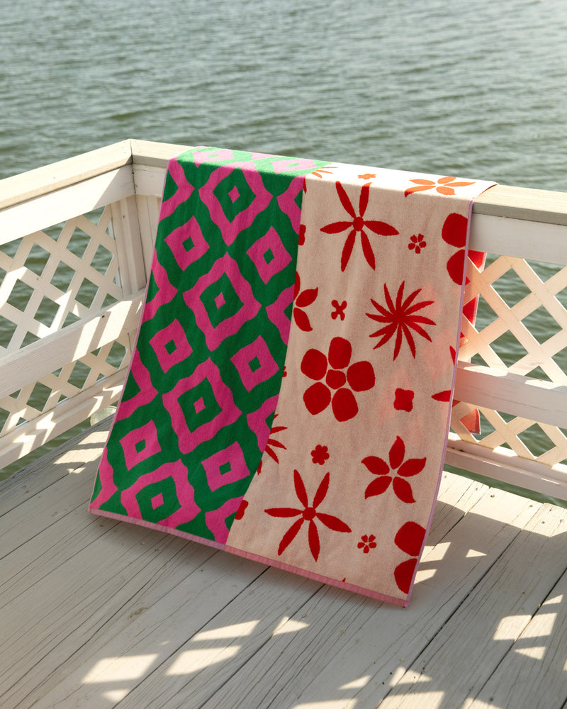 Patterned towel in peony pattern on wooden lattice railing