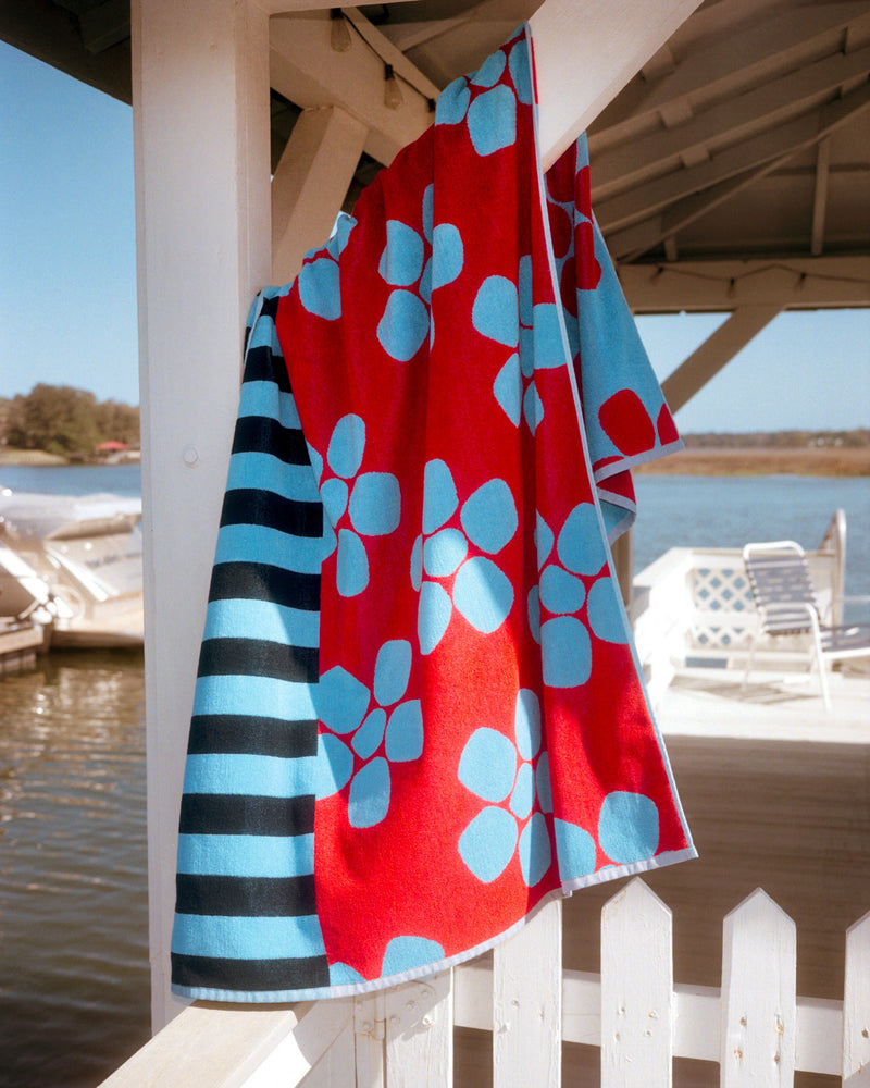 Periwinkle towel hanging over wooden support on dock