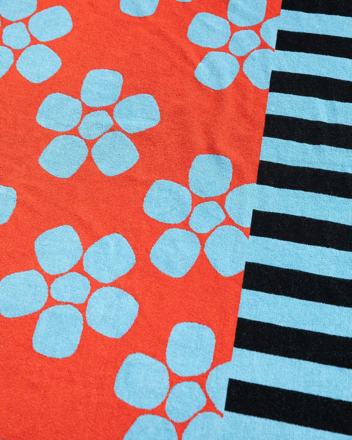 close up of Periwinkle towel in blue black and red florals