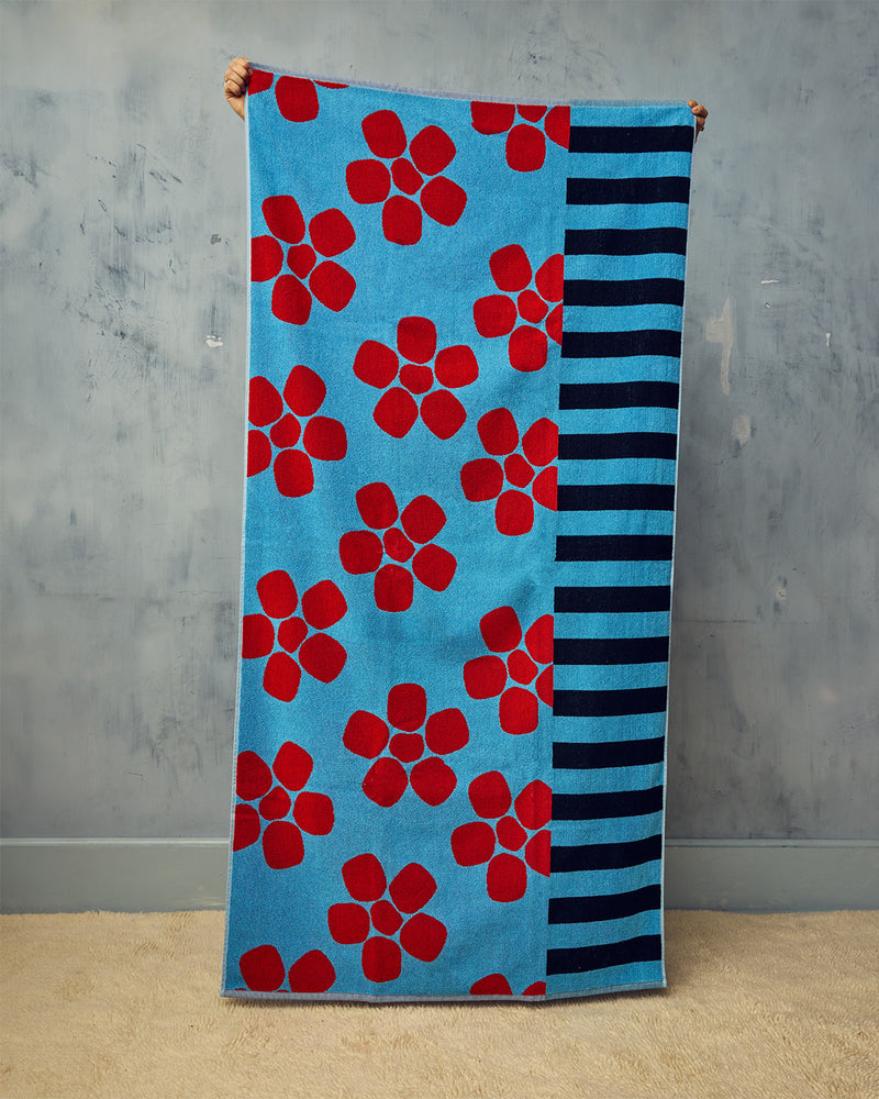 Towel with red floral pattern on blue background and black stripes on gray background