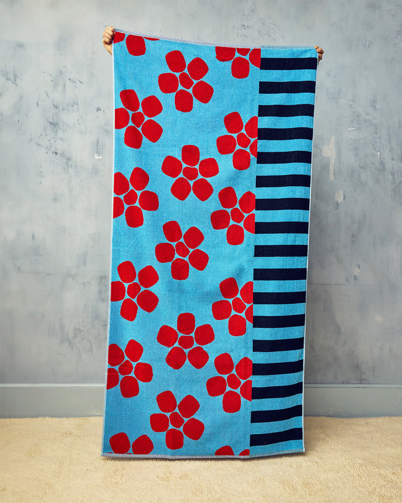 Towel with red floral pattern and black stripes on a blue background