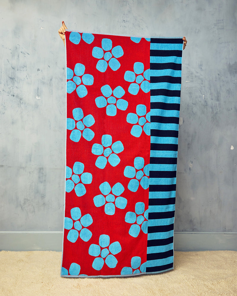 Towel with red background and blue floral pattern on a gray background