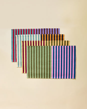 Set of four striped placemats on a beige background