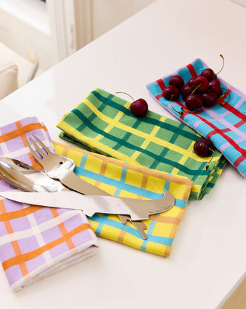 Set of 4 mixed napkins in Weave Colors Yellow, Blue, Green and Lavender. 100% Cotton, Dobby Weave, Mitered corners. On table