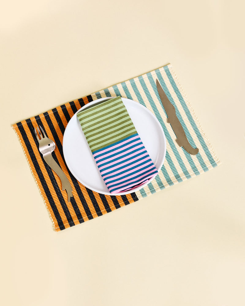 Placemat with striped napkin, fork, and knife on a beige background