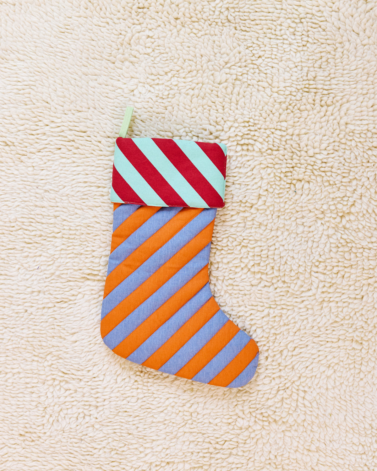 striped stocking in pumpernickel on beige carpet