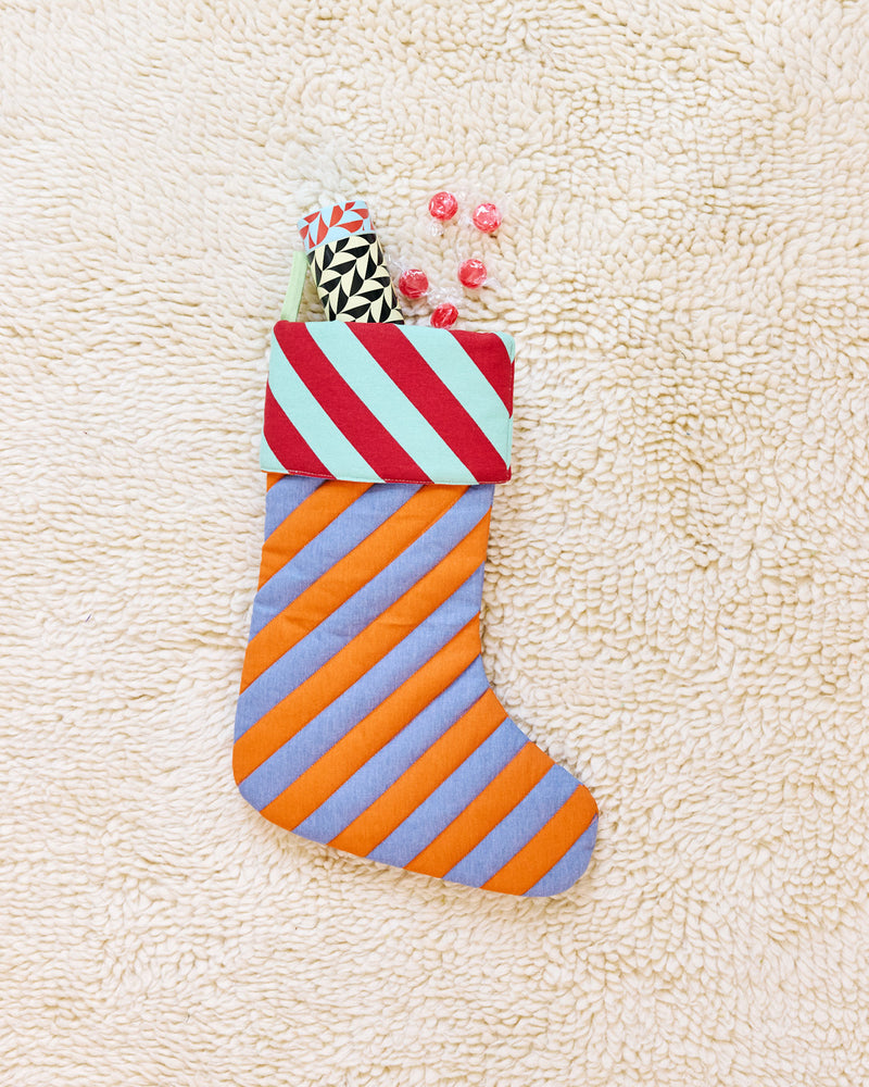 striped stocking in pumpernickel with red candies and insulated water bottle coming out