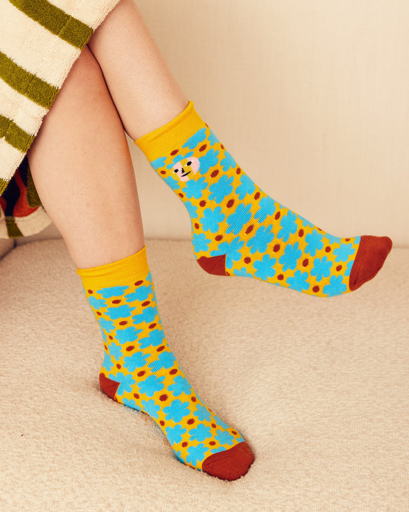 Raspberry socks in yellow and blue on legs