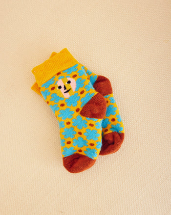 Raspberry patterned socks in yellow and blue flowers with brown dots on a beige background