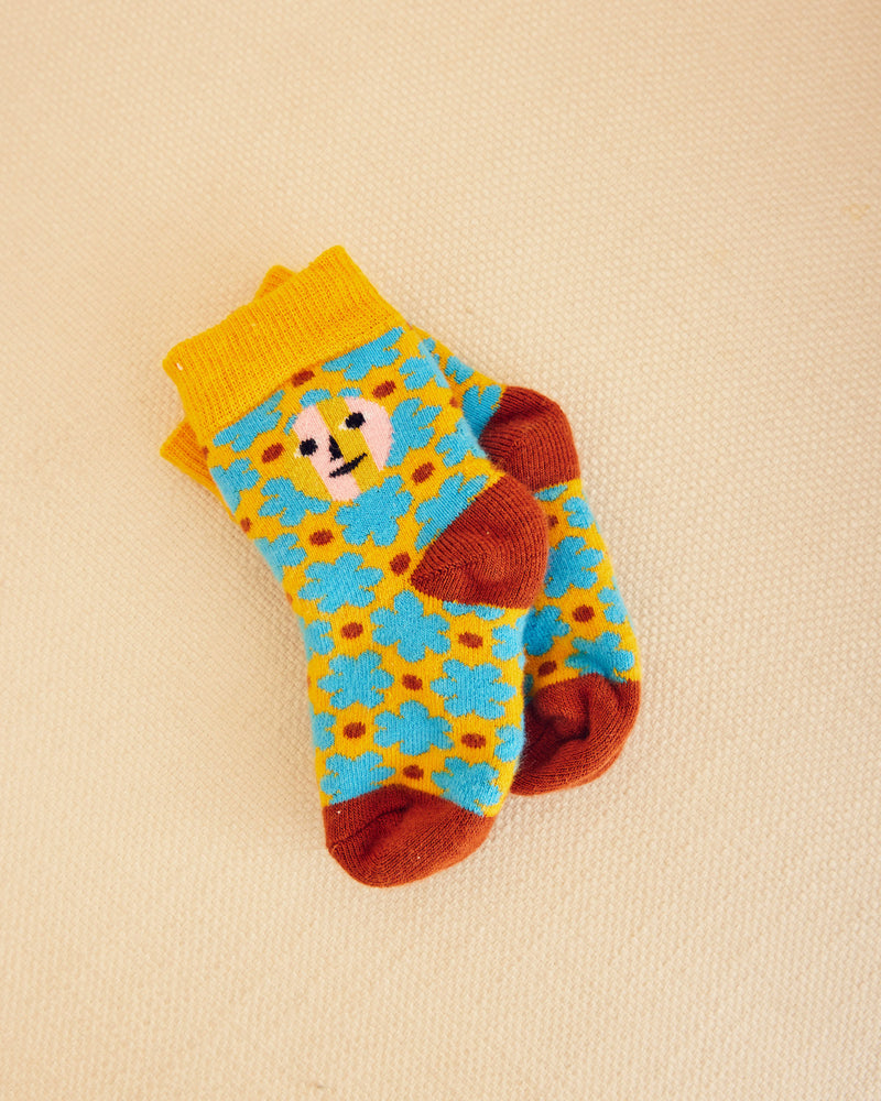 Raspberry patterned socks in yellow and blue flowers with brown dots on a beige background