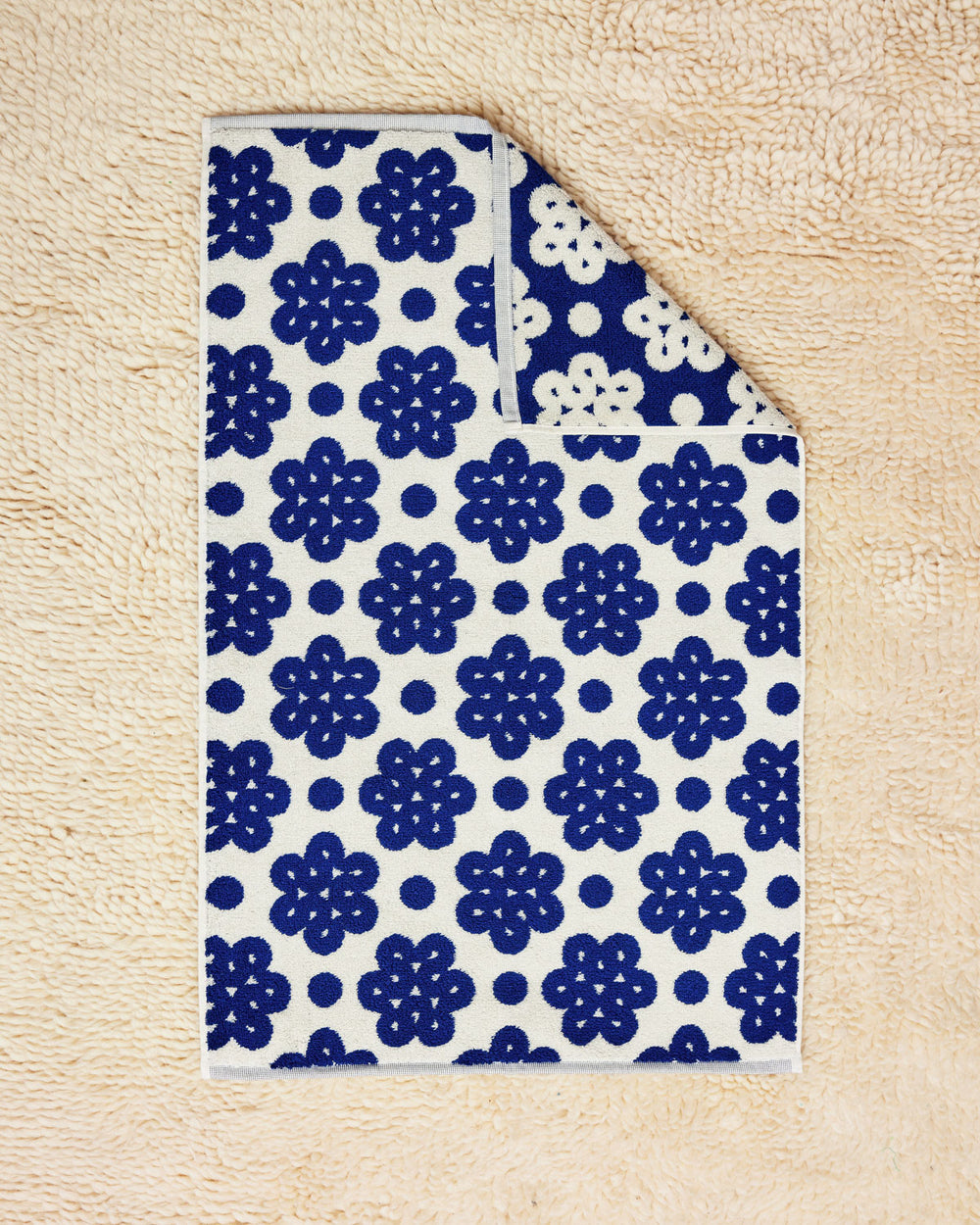 100% cotton towel with Raspberry Towel flat on cream rug 