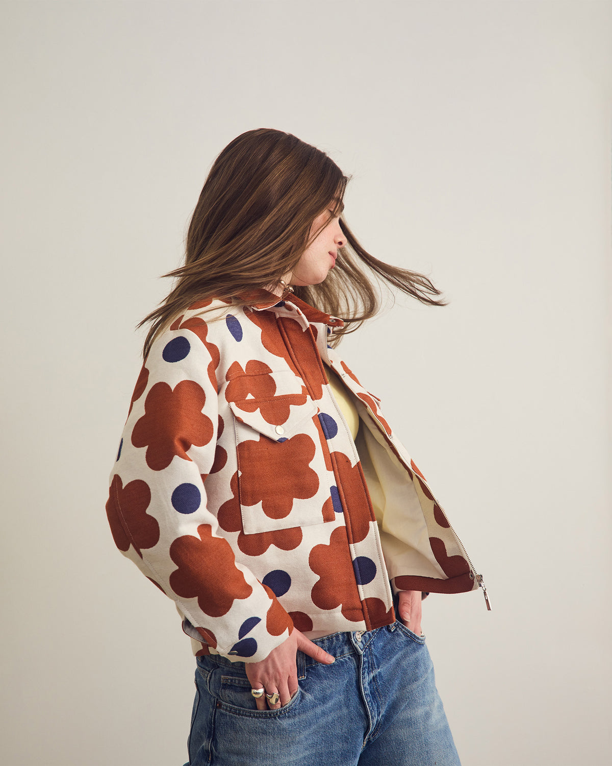 Person wearing a patterned jacket with a plain background