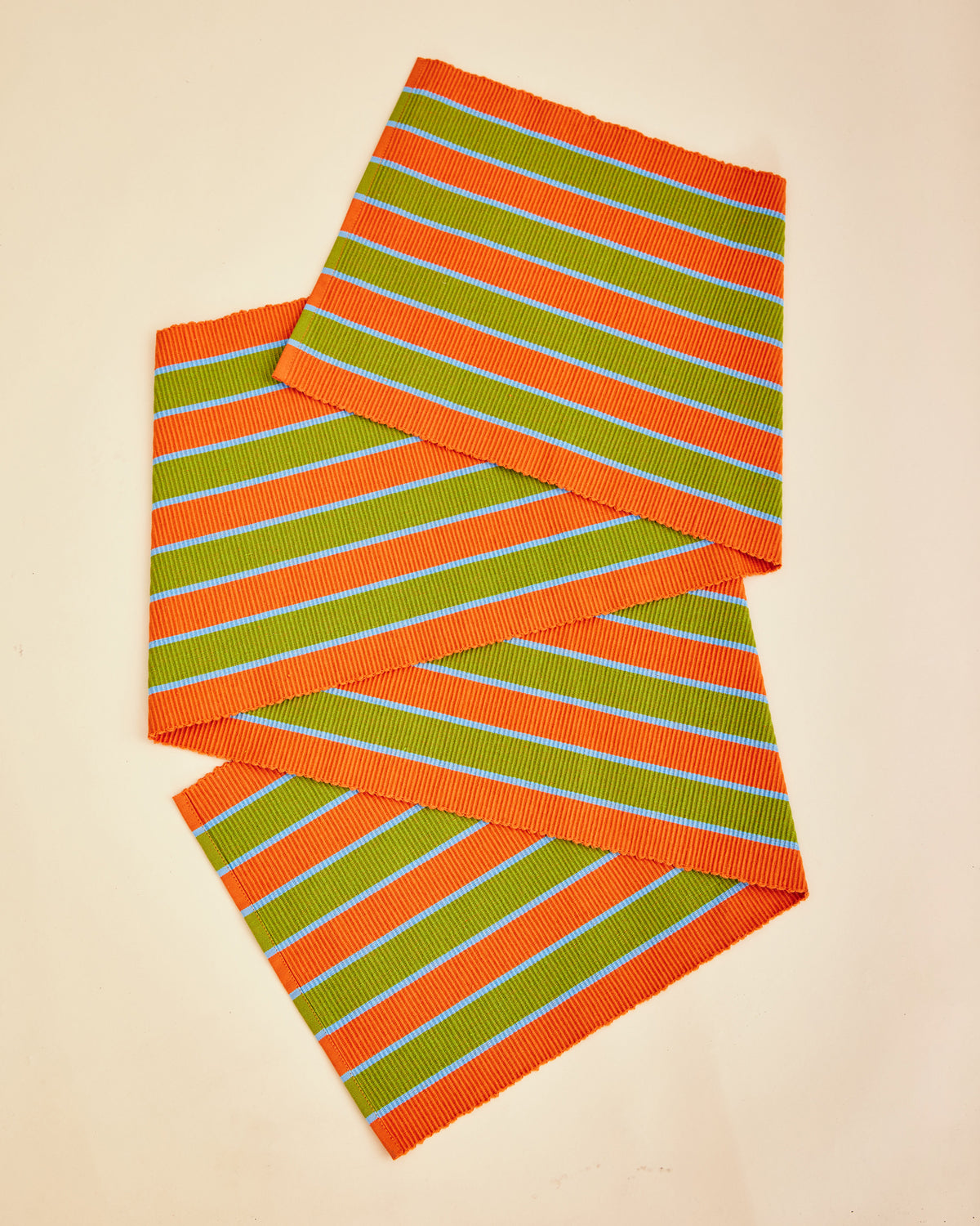 Dusen Dusen Saffron Stripe Runner. Runner in orange, green, and blue Saffron Stripe. Cotton runner in tri-color stripes with a ribbed texture. 100% cotton, 12" x 72". Machine wash cold and lay flat to dry. Spot clean as needed. Made in India.