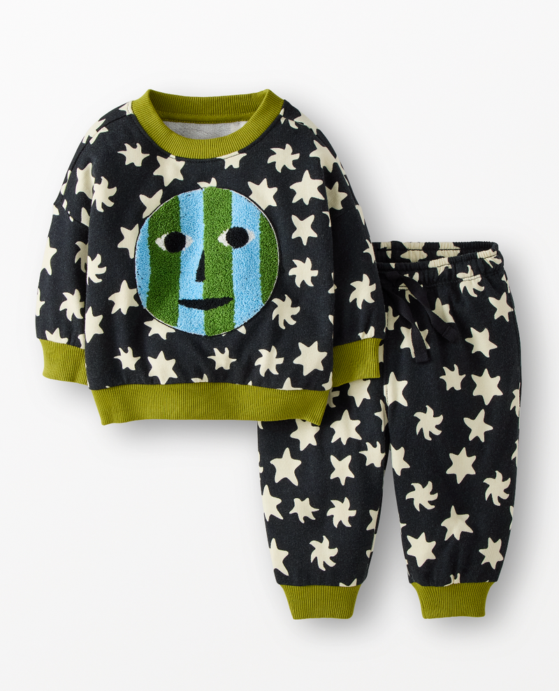 A two-piece children's pajama set featuring a long-sleeve top and matching pants. The set is dark charcoal gray with a pattern of cream stars and olive green trim.