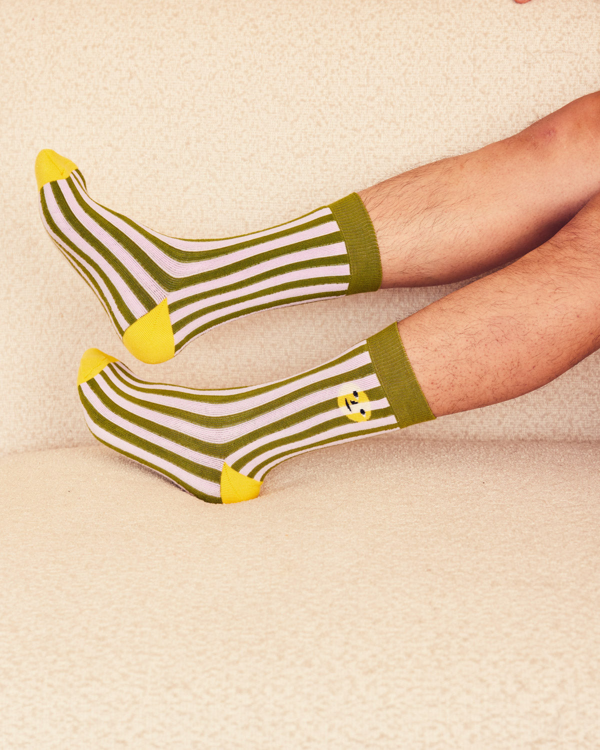 Sea stripe socks on men's legs on a beige background