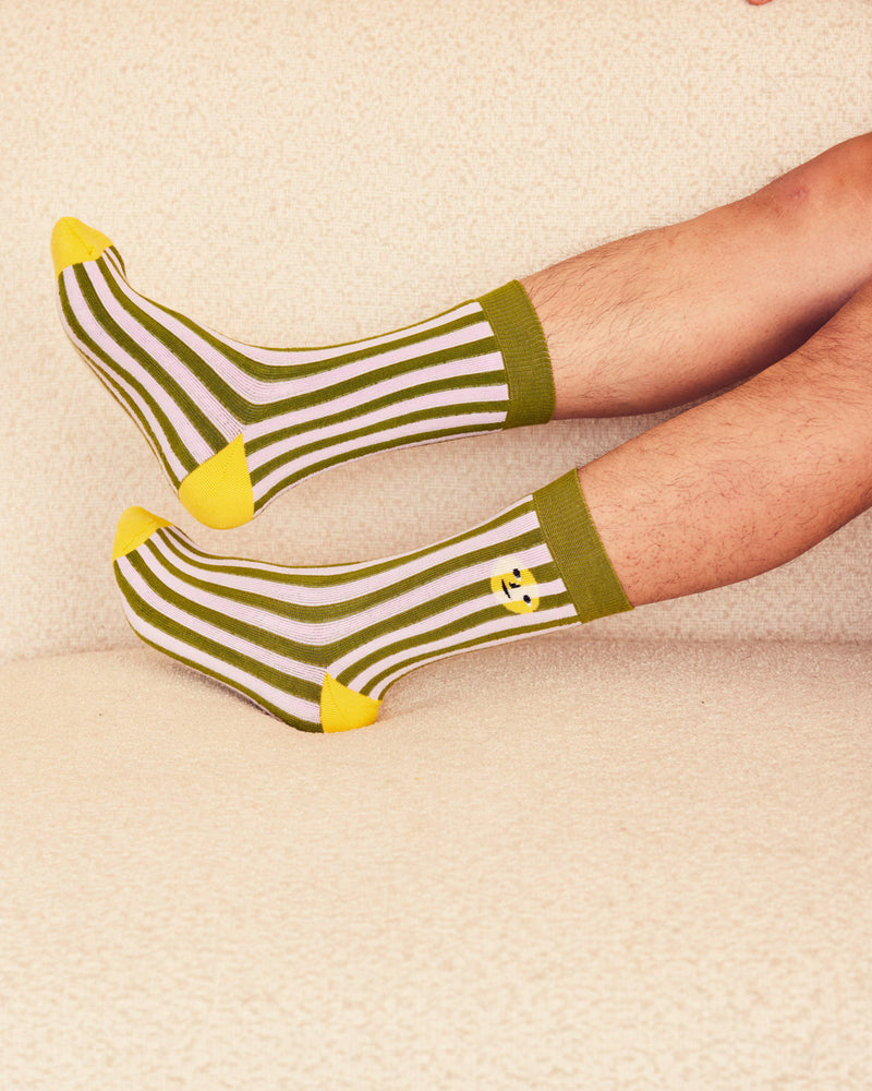 Sea stripe socks on men's legs on a beige background