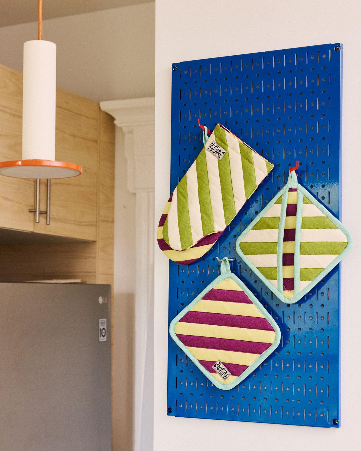 Sourdough oven mitts and two pot holders on a blue hanging board