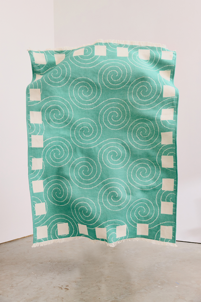 ["Teal fabric with white spiral pattern on a white background", " The one time it's good to Spiral on your couch"]
