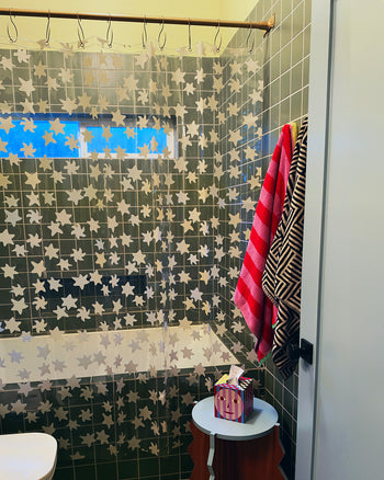 green tile bathroom with star shower curtain close up