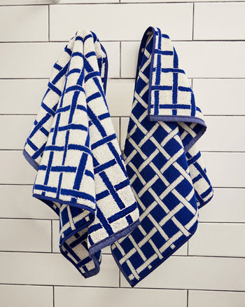 Blue and white checkered towels hanging on a tiled wall