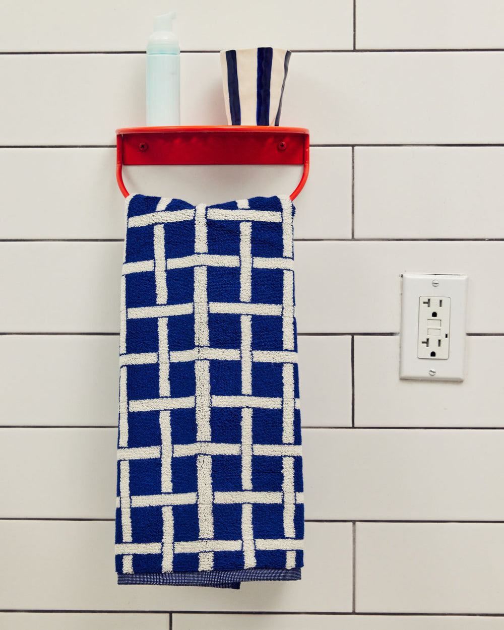 Tabby Towel handing from a red hook 