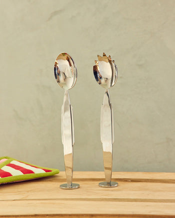 ["Serving spoon and fork on a wooden surface with a neutral background ", " Invite us to your next dinner party. We're a perfect team and we love to gossip. <br> <br>\nEach Set Includes 1x Fork and 1x Spoon"]