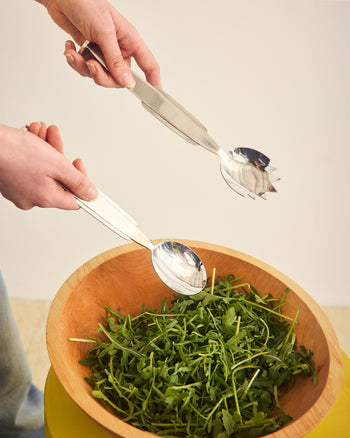 ["Wooden bowl with arugula and metal serving spoon and fork on a neutral background ", "  Invite us to your next dinner party. We're a perfect team and we love to gossip. <br> <br>\nEach Set Includes 1x Fork and 1x Spoon"]