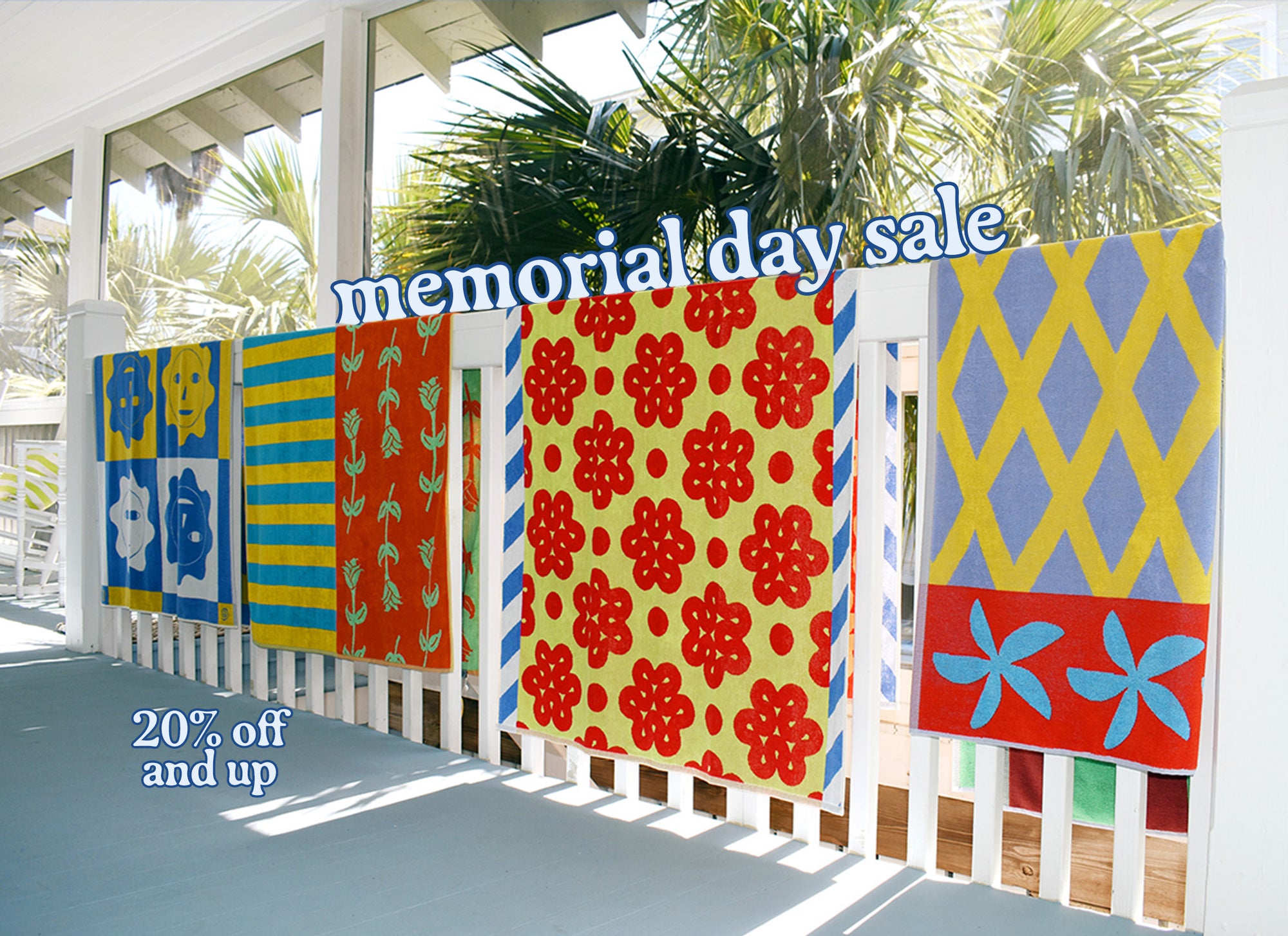 Fence, Raspberry, Rose and Sun beach towel all hanging over a banister with memorial day sale in white text on top of banister. 