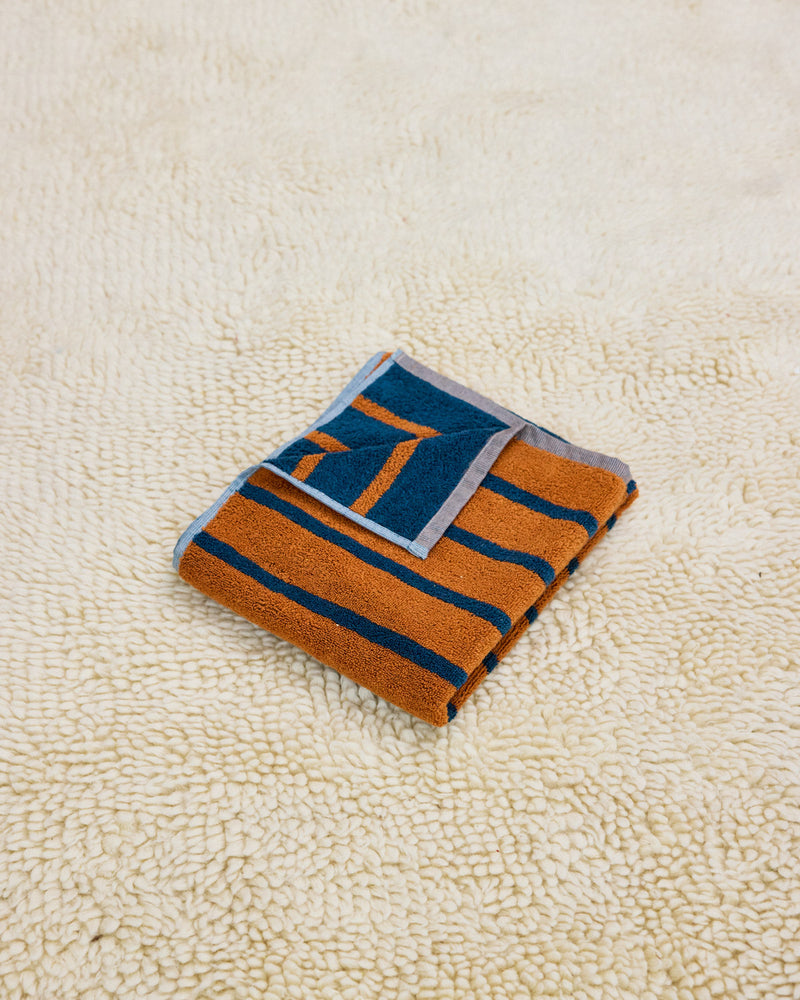 orange and navy stripe towel on rug