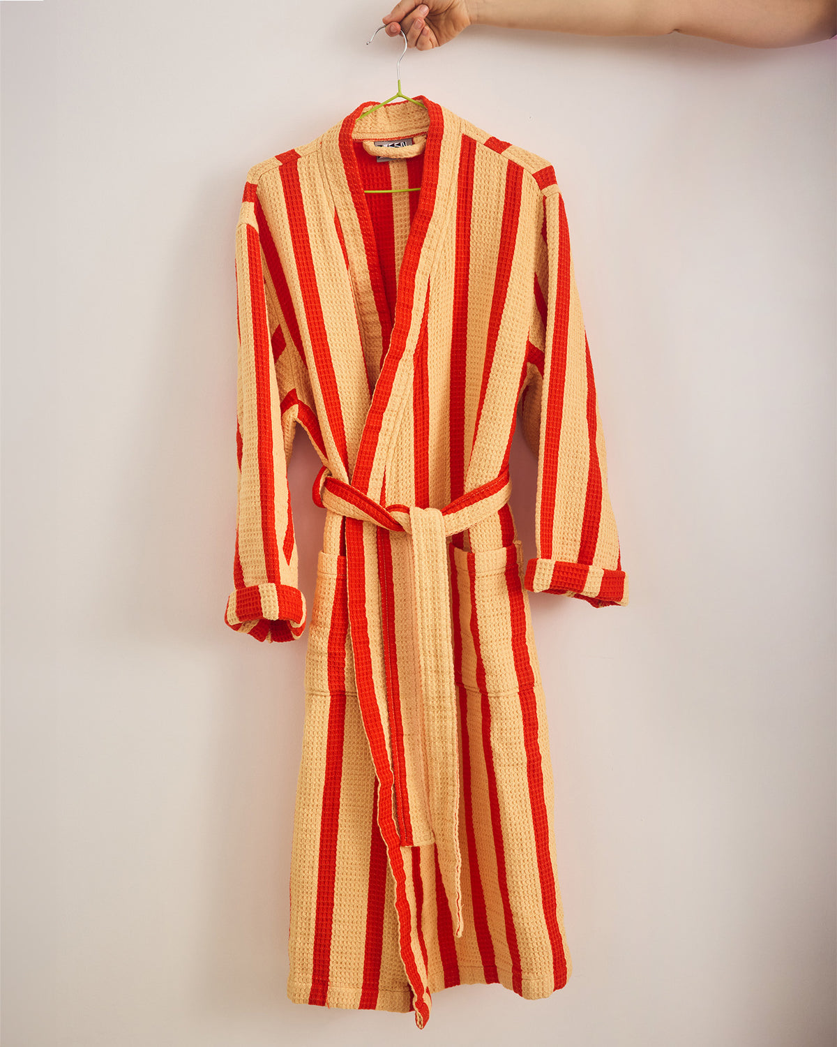 Red and yellow striped robe hanging on a white wall