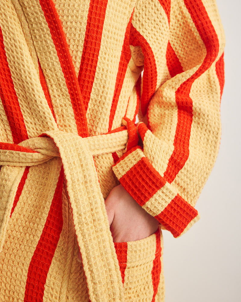 Close-up of a red and yellow striped robe with a white background