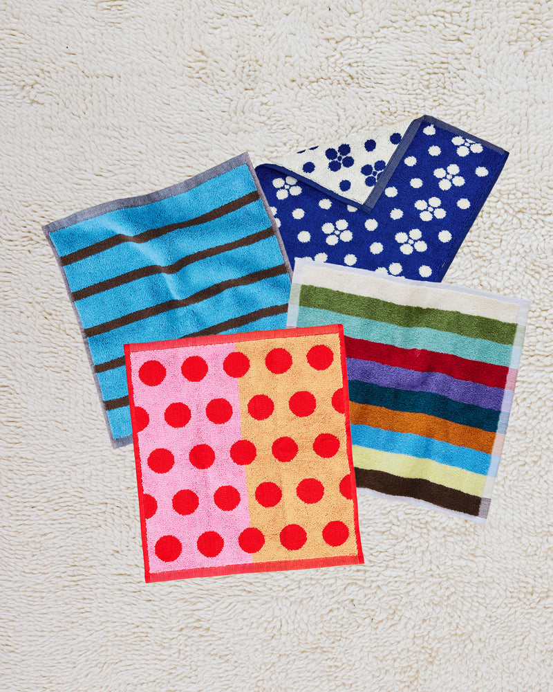 ["Four colorful towels with different patterns on a textured surface ", " It's a washcloth party, and everyone's invited <br> <br>Comes with:\n<br>\n1 Lisa Washcloth (from Navy Towel Collection)<br>\n1 Hummingbird Washcloth (from our Hummingbird Towel Collection)<br>\n1 Heron Washcloth (from our Bird Stripe Towel Collection)\n1 Dot Washcloth (from our Dot Towel Collection)"]