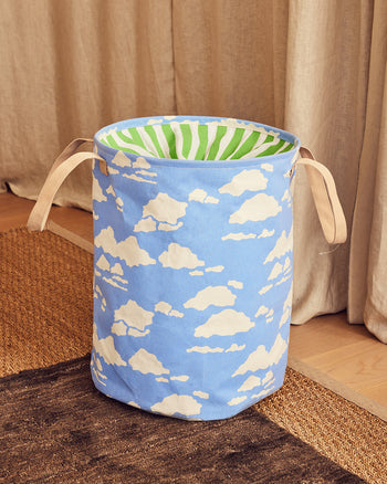 Blue laundry basket with cloud pattern on a wooden floor 