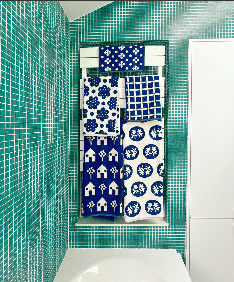 full set of navy towels in green tile bathroom