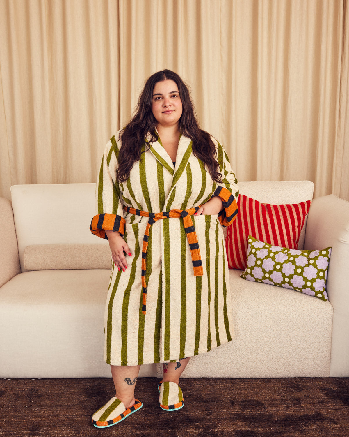 Carmen wearing Juniper robe in front of couch with two pillows on it