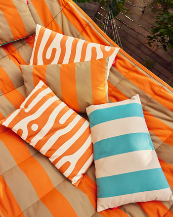 ["Fatboy x Dusen Dusen Outdoor King Pillow in Stripe and Oak. One in Dark Brown and Orange, the other in white and blue based on the ground and sky. Oak in orange-rust brown and white. UV-resistant, Water resistant, Stain resistant. all three pillows on hammock ", " You will not get in trouble if you bring this pillow indoors"]
