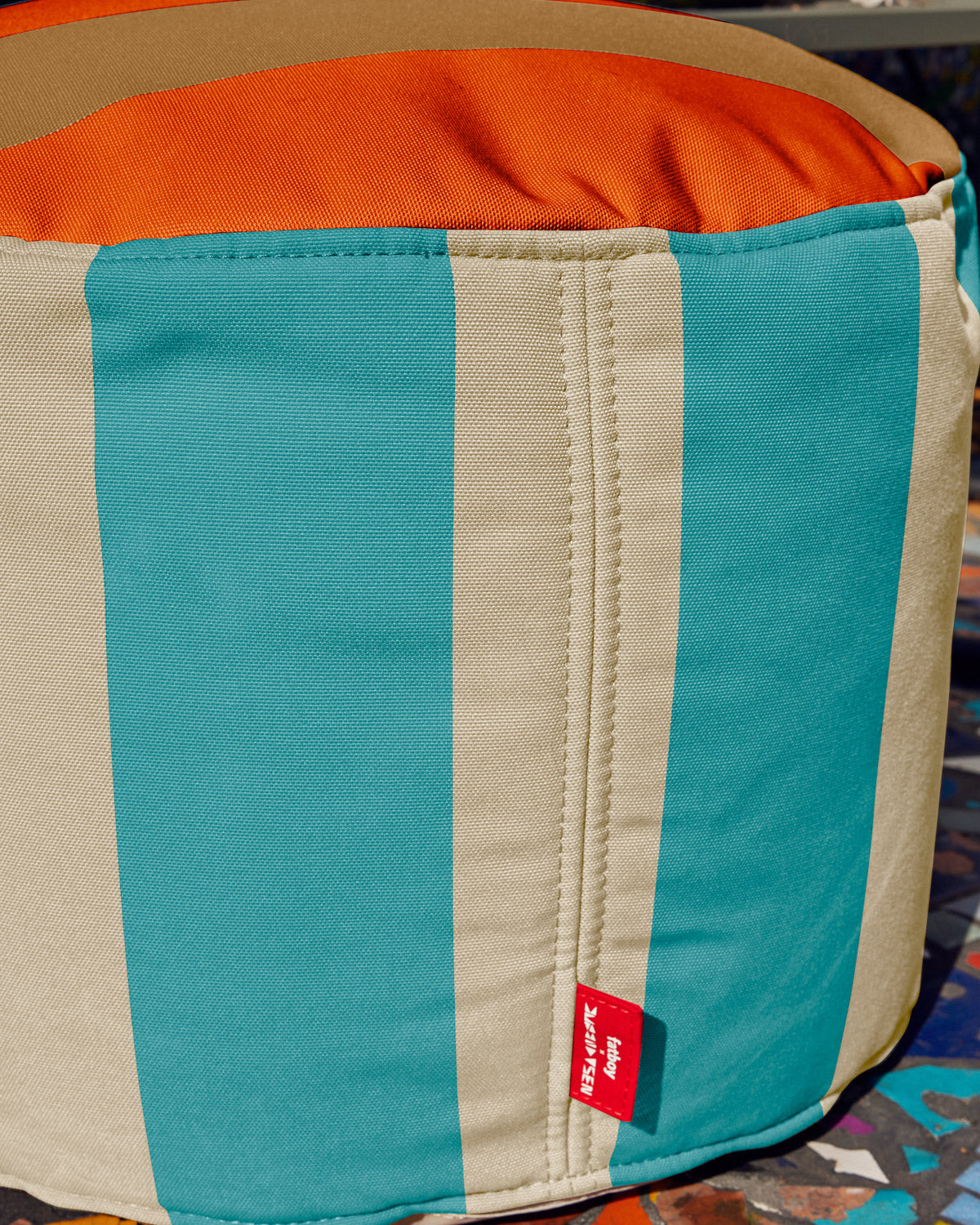 Fatboy x Dusen Dusen Outdoor Point Pouf Stripe. One in Dark Brown and Orange, the other in white and blue based on the ground and sky. 