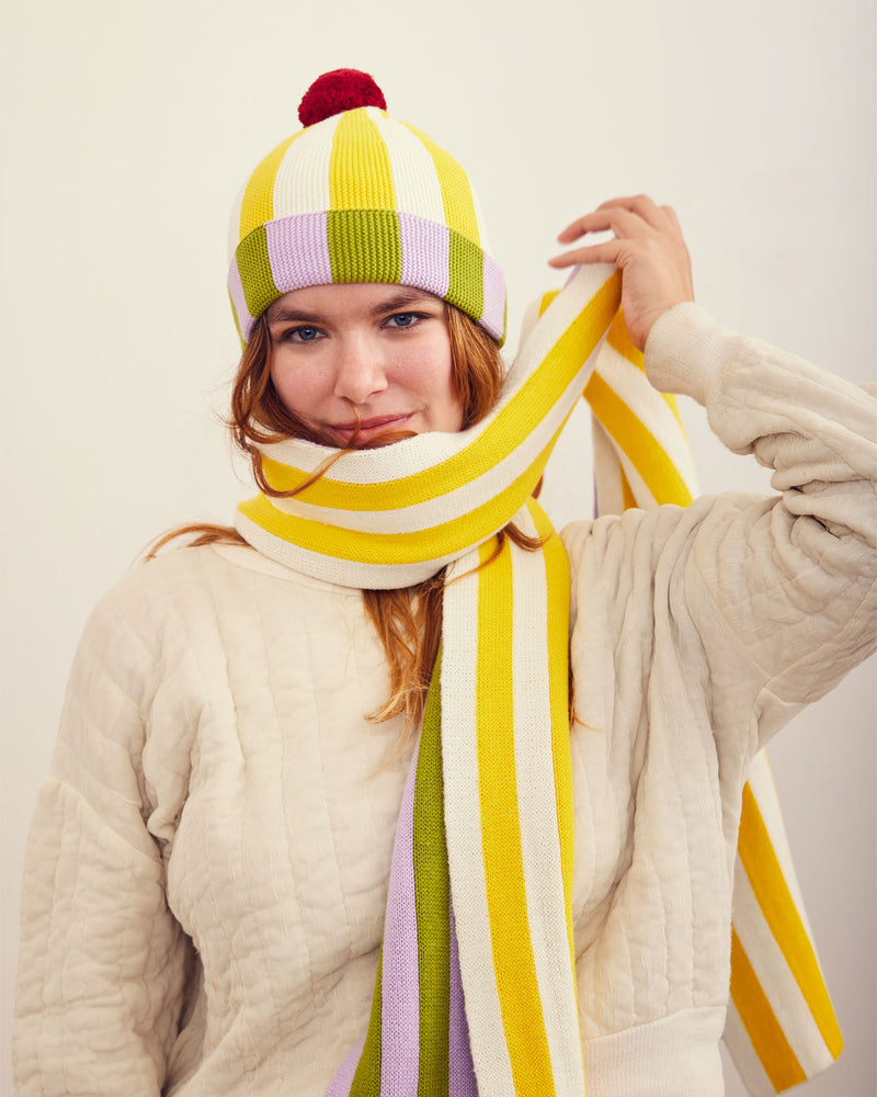 Squash Stripe Scarf. Reversible stripe scarf with contrasting yellow, white, lilac, and green stripes. 100% Cotton. Made in China.
