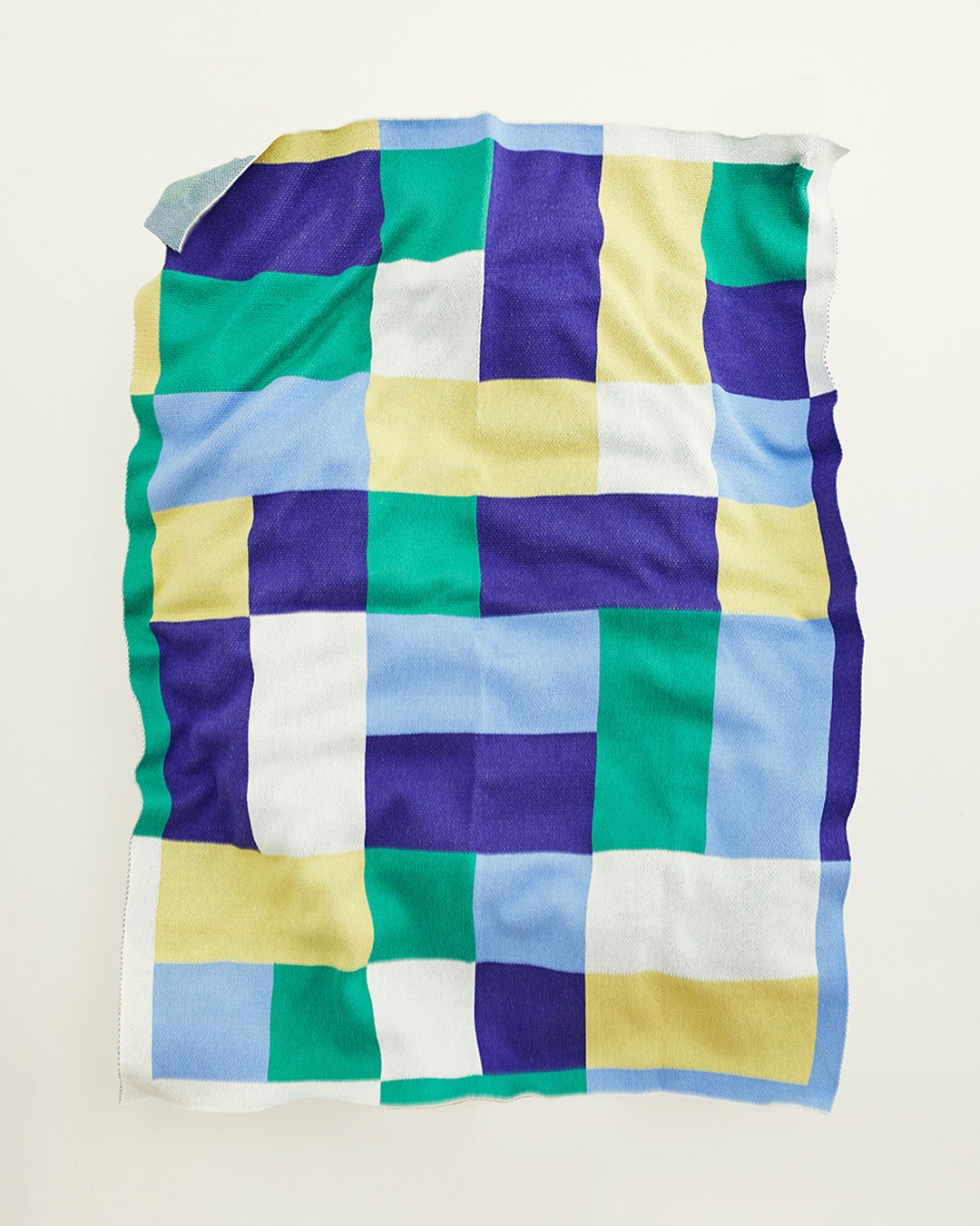 Dusen Dusen Throw in Aubette pattern. Cotton knit throw in periwinkle, indigo, green, white, and chartreuse. 100% cotton, medium weight, soft & cozy. 50" W x 70" H. Machine wash cold, tumble dry low. Made in China