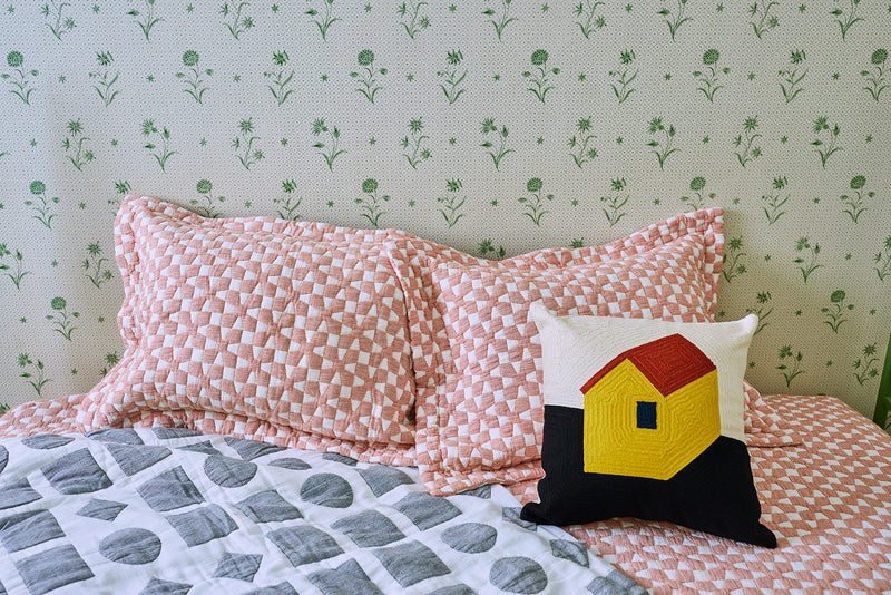 House Pillow up against red and white quilt and vintage wall paper