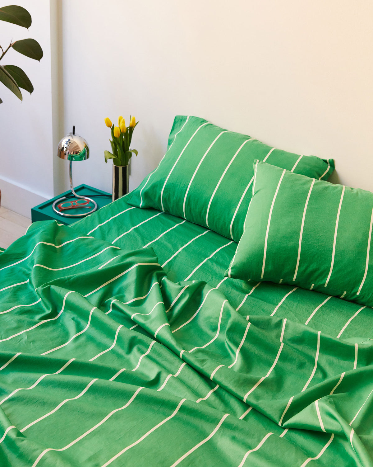 Dusen Dusen Lawn Stripe Sheets. Sheeting in green and white stripes. 100% cotton sateen, 300 thread count. Machine wash cold and tumble dry. Made in Portugal. Our cotton sateen is smooth and cool to the touch and features a slightly lustrous finish.