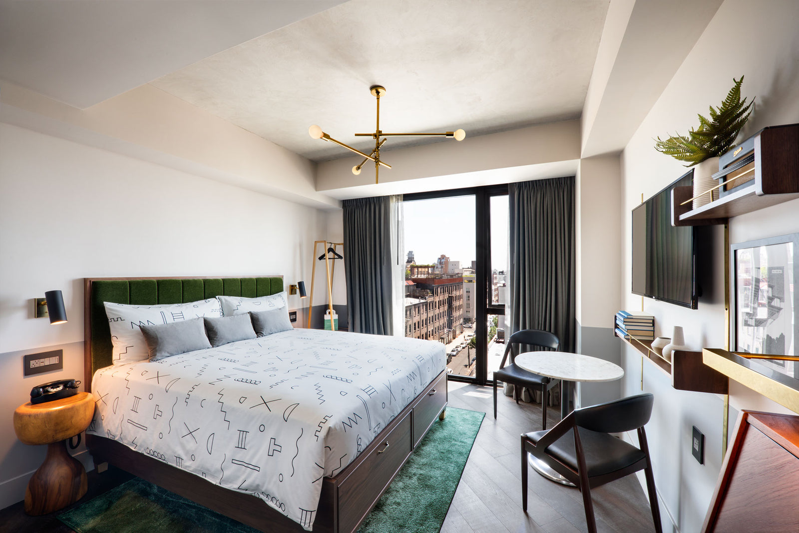 wide shot of hotel room in anothr arrangement with black line pattern bedding