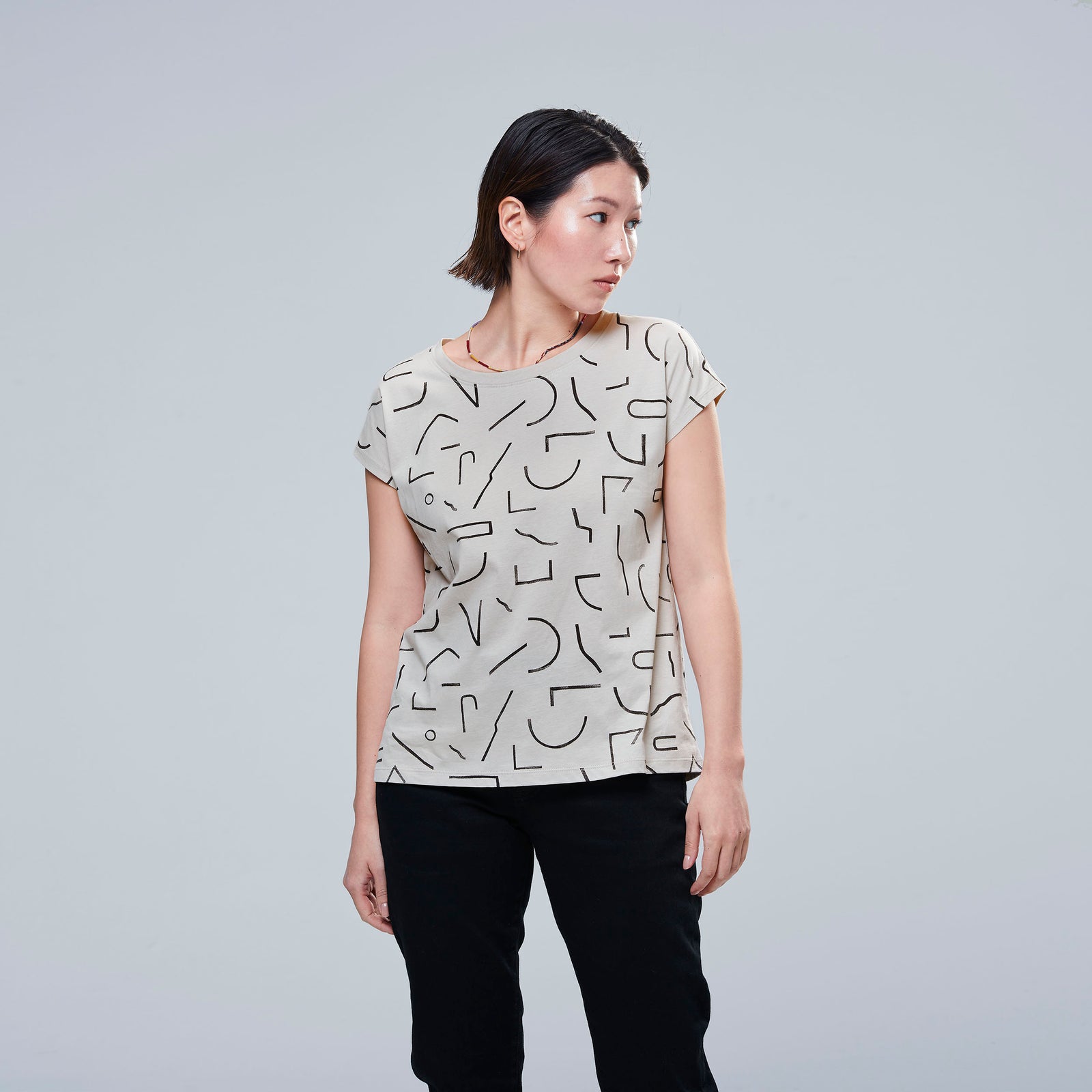 woman in beige t shirt with block line pattern on top