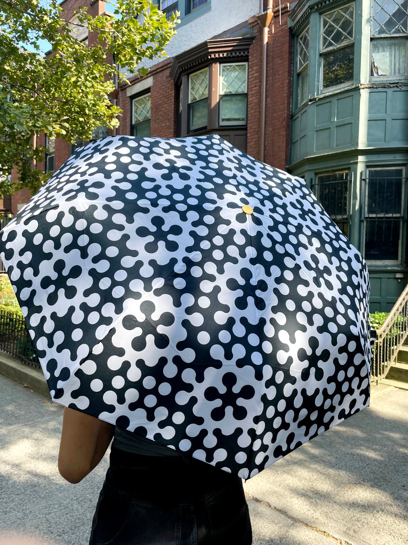 Dusen Dusen for Areaware Pattern Umbrella. Pattern Umbrella made in collaboration with Areaware. Black and white Atom print. Button for automatic opening. Nylon, metal, plastic. Comes with coordinating carrying bag. Made in China.