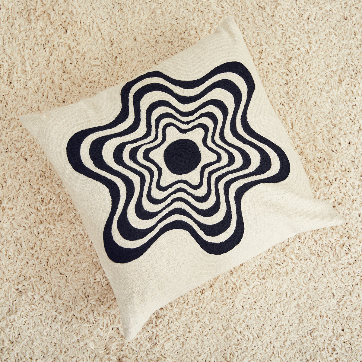 Dusen Dusen Flower pillow. Embroidered pillow in black and white Flower print. 100% cotton embroidery. Non-embroidered natural canvas back with a zipper opening. Made in India. Polyfill-down alternative inserts mimic the fluffiness of natural down. Insert is made in the USA.