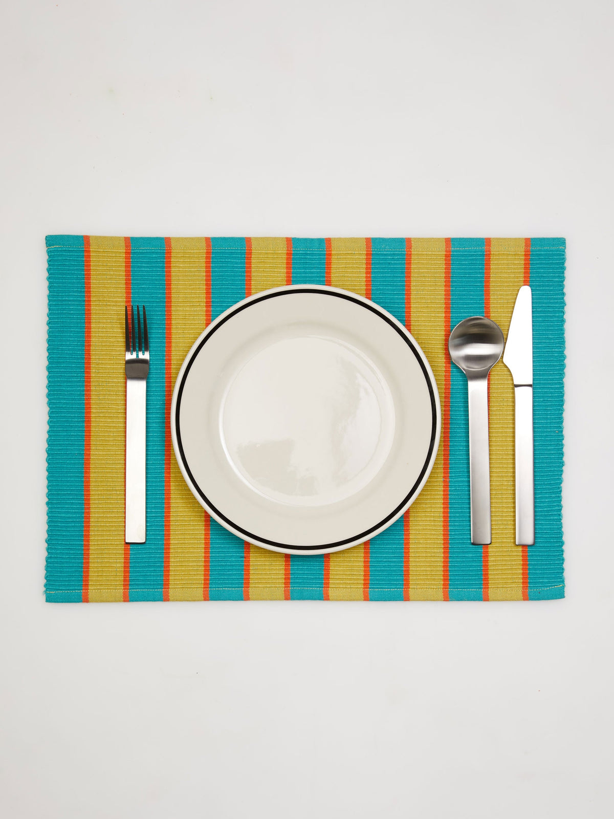 Dusen Dusen Parmesan Striped Placemat. Cotton placemats in tri-color stripes with a ribbed texture. 100% cotton, 12" x 18". Machine wash cold and lay flat to dry. Spot clean as needed. Made in India.